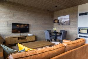 a living room with a couch and a table at Mosetertoppen Skiline - Hafjell Ski Resort in Øyer