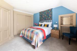 ein Schlafzimmer mit einem Bett und einer blauen Wand in der Unterkunft Lock Keepers Cottage, Loch Ness Cottage Collection in Inverness