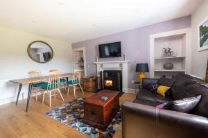 ein Wohnzimmer mit einem Sofa und einem Tisch in der Unterkunft Lock Keepers Cottage, Loch Ness Cottage Collection in Inverness