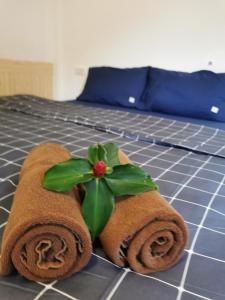 a pair of towels with a plant on a bed at De​ Lanta place in Ko Lanta