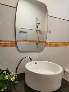 a bathroom with a white sink and a mirror at De​ Lanta place in Ko Lanta