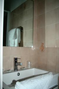 y baño con lavabo y espejo. en Hôtel Les Castets d'Ayré en Barèges