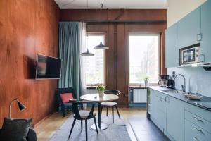 a kitchen with a table and chairs in a room at The Nooq Malmö - Hotel & Studios in Malmö +14 photos