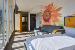 um quarto com uma cama e uma pintura de flores na parede em Buddy Hotel em Munique