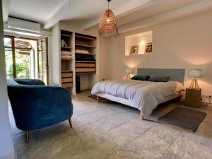 a bedroom with a bed and a blue chair at La Bergerie Fiumicellu in Santa-Maria-di-Lota +33 photos