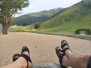 una persona con los pies en la parte superior de un camino en Charmant logement sur la station de Val Louron en Val Louron