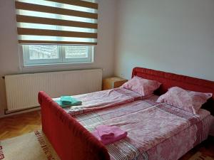 a bedroom with a red bed with two towels on it at Kuca za odmor RADMILA - Rogljevacke pivnice in Rogljevo