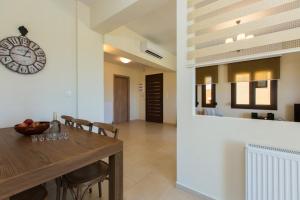 een eetkamer met een tafel en een klok aan de muur bij Family villa, Fantastic views, Private pool, Free laptop 1 in Roúpai