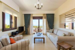 un soggiorno con divano e tavolo di Family villa, Fantastic views, Private pool, Free laptop 1 a Roúpai