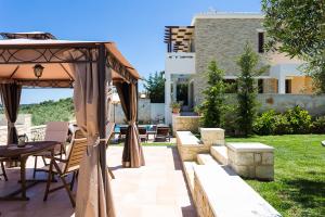 un patio con mesa y cenador en Family villa, Fantastic views, Private pool, Free laptop 1 en Roúpai