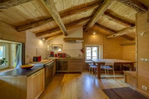 eine Küche mit Holzdecken und einem Holztisch in der Unterkunft L'Echappée en Vercors in Choranche
