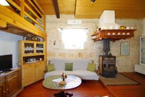 salon z kanapą i piecem opalanym drewnem w obiekcie Holiday house Franko w mieście Rakalj