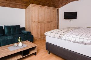 a bedroom with a bed and a couch and a table at Central-Inn Werfen in Werfen