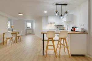 a kitchen with white cabinets and a table and chairs at Alojamiento Maite Jaca in Jaca
