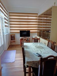 a dining room with a table and a television at Kuca za odmor RADMILA - Rogljevacke pivnice in Rogljevo