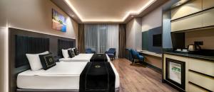 a hotel room with two beds and a desk at Hidden Hills Hotel Istanbul Airport in Istanbul