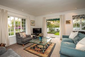 a living room with a blue couch and a glass table at Greenhill Farm Cape Dutch Cottage Plettenberg Bay - 1 Bedroom Private Cottage in Plettenberg Bay
