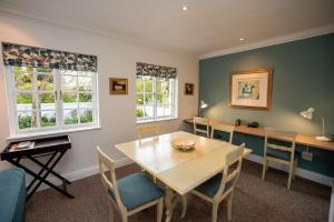 a dining room with a wooden table and chairs at Greenhill Farm Cape Dutch Cottage Plettenberg Bay - 1 Bedroom Private Cottage in Plettenberg Bay