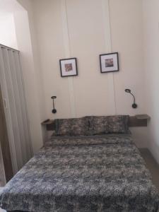 a bed in a bedroom with three pictures on the wall at L'Ambre d'Or in Falicon