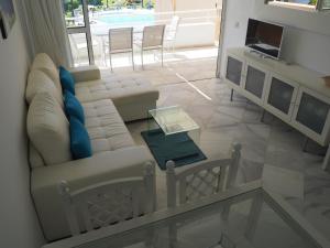 伊斯蘭蒂拉的住宿－atico en Las Americas Islantilla primera línea de playa，客厅配有沙发和桌子