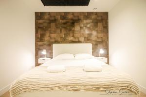 ApartHotel Boutique by Urban Home Stay في ألكمار: غرفة نوم بسرير كبير مع وسادتين بيضاء