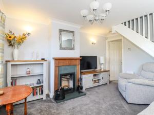 a living room with a fireplace and a chair at Honeybee Cottage in Ripon