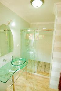 y baño con mesa de cristal y ducha. en Elevate Suites Gisenyi, en Gisenyi