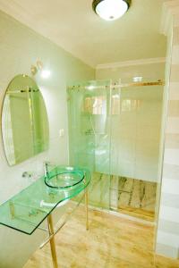 a bathroom with a glass table and a shower at Elevate Suites Gisenyi in Gisenyi