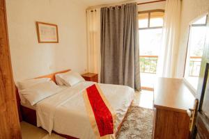 ein Hotelzimmer mit einem Bett und einem Fenster in der Unterkunft Elevate Suites Gisenyi in Gisenyi