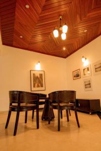 two chairs and a table in a room with a ceiling at Elevate Suites Gisenyi in Gisenyi