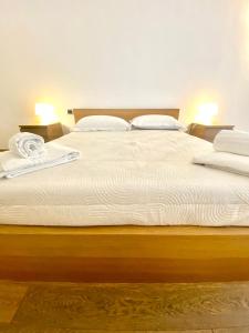 uma cama grande com lençóis brancos e almofadas em HomeClass em Bari