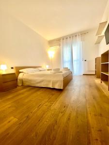 a large bedroom with a bed and a wooden floor at HomeClass in Bari
