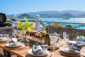 a wooden table with plates and wine glasses on it at A Point of View in Airlie Beach