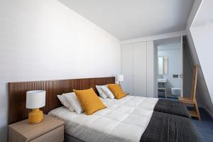 1 dormitorio con 1 cama grande con almohadas amarillas en Piso Azul Premium Apartments in Bairro Alto by LovelyStay, en Lisboa