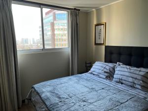 a bedroom with a bed and a large window at 20,Costado Clinica Las Condes,5 Personas in Santiago