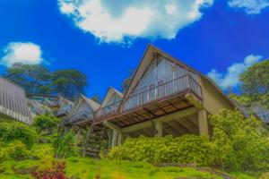 une maison entourée d'une terrasse sur une colline dans l'établissement Hummingbird St.Clare Villas, à Dimbula
