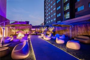 波多的住宿－HF菲尼克斯波爾圖酒店，一个带紫色和白色椅子及遮阳伞的庭院