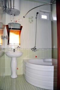 a bathroom with a tub and a sink and a bath tub at Bargi Sabz in Khujand