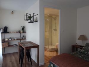 a bathroom with a table and a shower in a room at Agréables chambres indépendantes - Coutances centre in Coutances