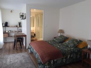 1 dormitorio con cama, mesa y escritorio en Agréables chambres indépendantes - Coutances centre, en Coutances