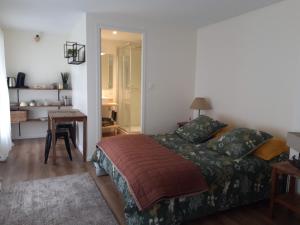 a bedroom with a bed and a table and a desk at Agréables chambres indépendantes - Coutances centre in Coutances
