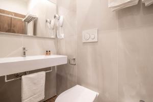 a white bathroom with a toilet and a sink at DANY GUEST HOUSE in Rome