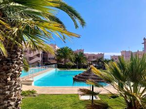 a swimming pool in a resort with a palm tree at Casa Da luz 5 - sea view 2 bedrooms apt , beach & swimming-pool in Luz