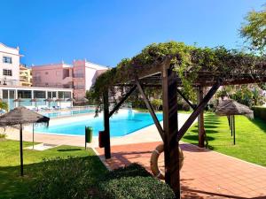 a view of a swimming pool with umbrellas at Casa Da luz 5 - sea view 2 bedrooms apt , beach & swimming-pool in Luz