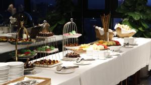 a white table with a buffet of food on it at The Penthouse Residence in Phnom Penh