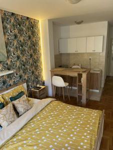 um quarto com uma cama e uma cozinha com uma mesa em Vert Cozy Apartment Free Parking em Novi Sad