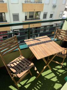 uma mesa de madeira e cadeiras numa varanda em Vert Cozy Apartment Free Parking em Novi Sad