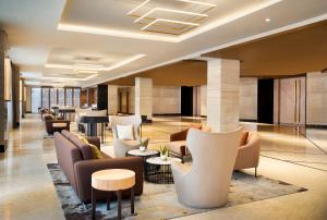 a lobby of a hotel with couches and tables at ARTOTEL Suites Mangkuluhur Jakarta in Jakarta