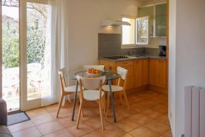 una cocina con mesa de cristal con sillas, mesa y mesa. en La Françonne Blanc - Gîte de charme en Provence, en Mirabel-aux-Baronnies