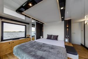 a bedroom with a large bed and a large window at Houseboat Nomadream in Gdańsk